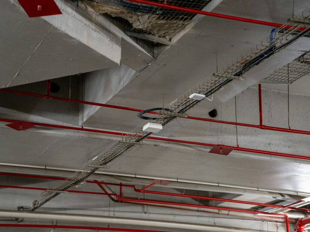 Red fire protection pipework under a concrete ceiling